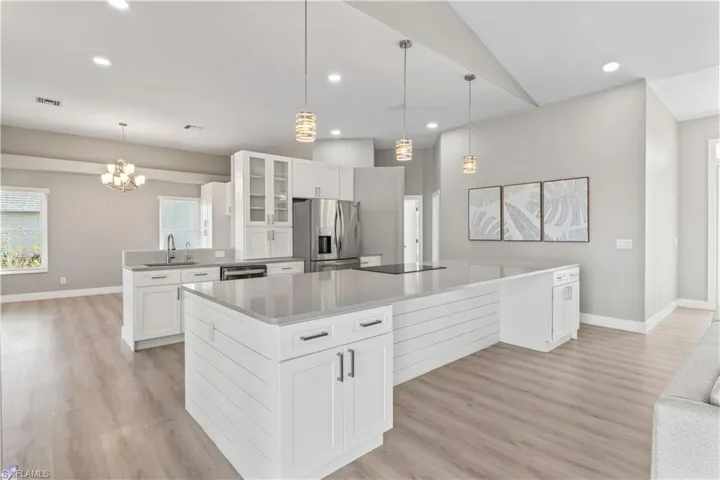 Kitchen with white cabinetry, glass insert cabinets, healthy amount of natural light, appliances with stainless steel finishes, and recessed lighting