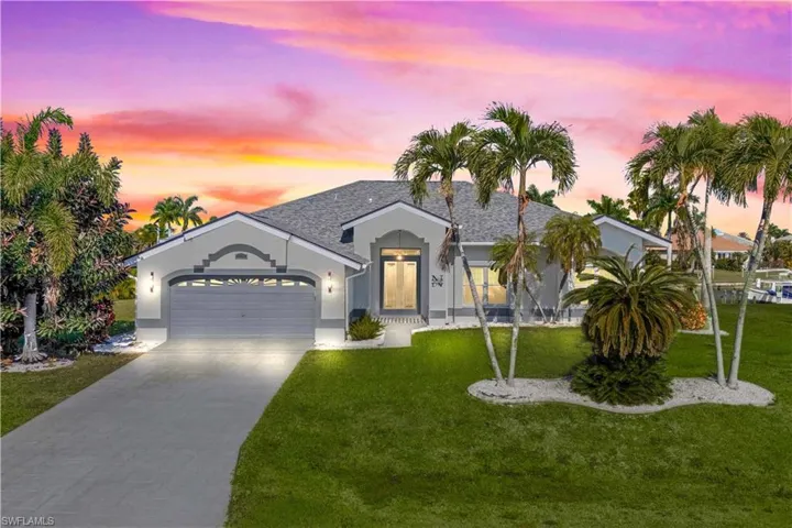 Single story home with driveway, a garage, stucco siding, and a front lawn