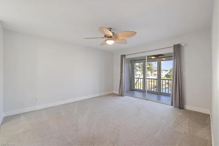 Empty room with light carpet and a ceiling fan