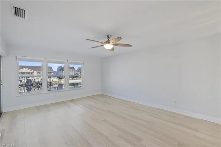 Empty room with a ceiling fan and light wood finished floors