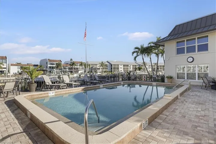 Community pool with a patio area and a residential view