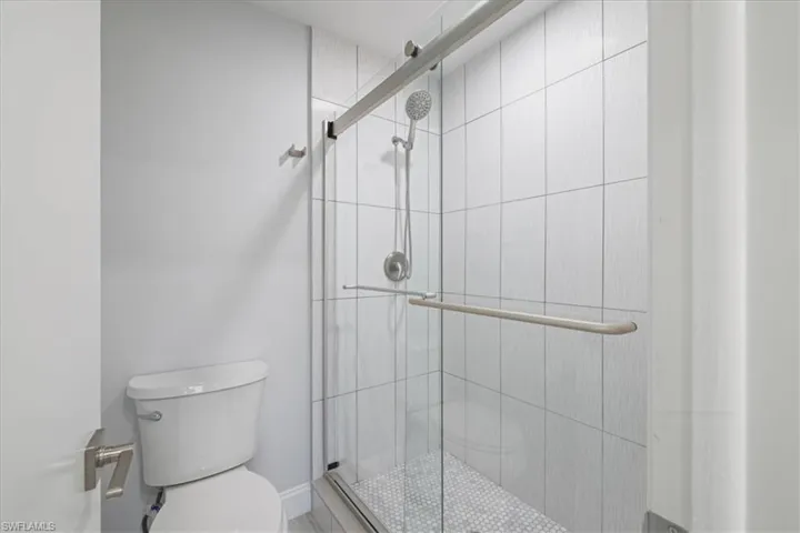 Bathroom featuring toilet and a shower stall