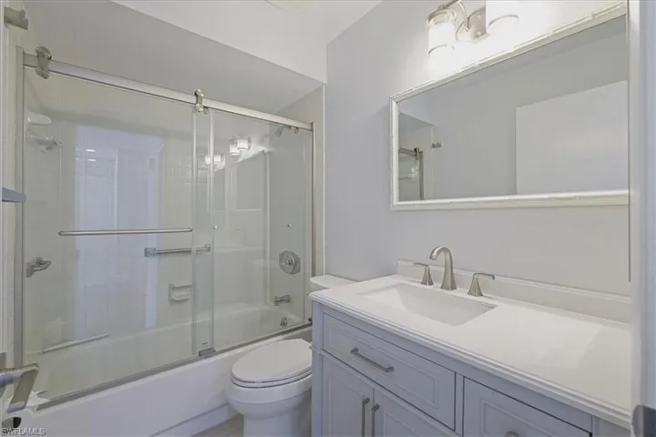 Full bath with vanity and combined bath / shower with glass door