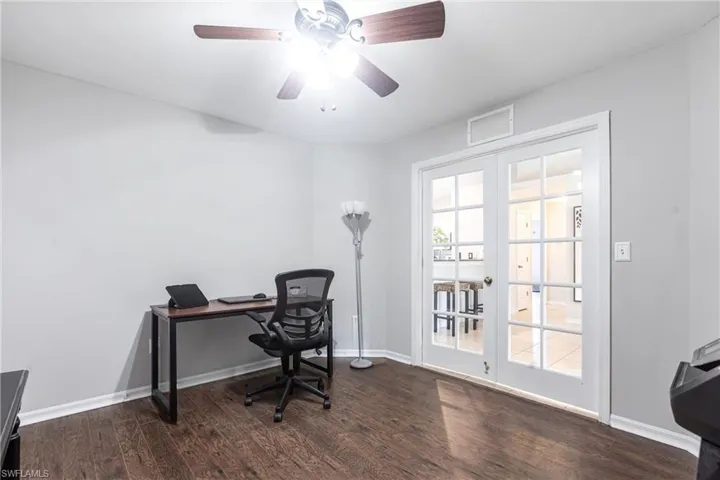 Home office with wood finished floors and a ceiling fan