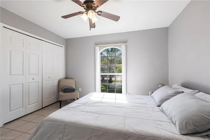 Tiled bedroom with a closet and a ceiling fan