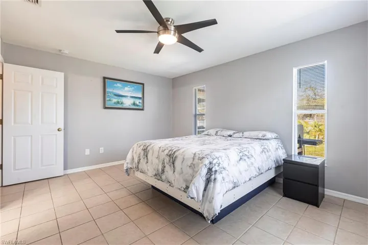 Bedroom with light tile patterned flooring and a ceiling fan
