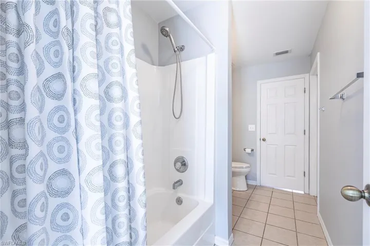 Bathroom featuring tile patterned flooring and shower / bath combo