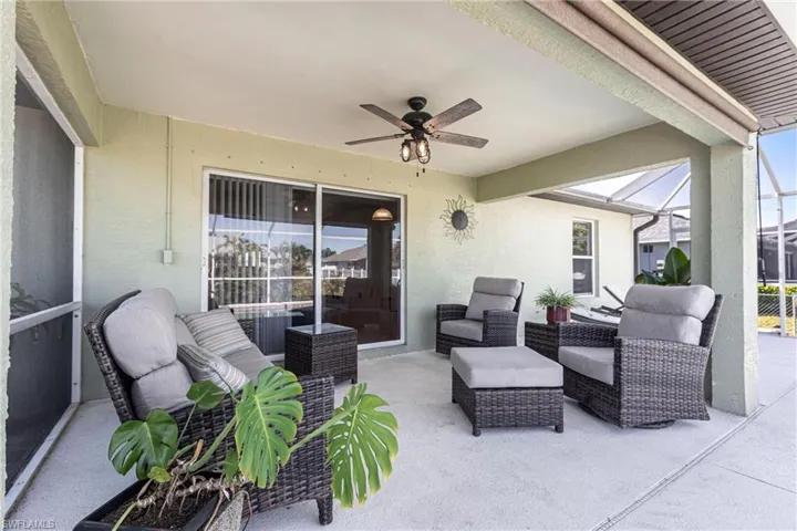 View of patio / terrace with a ceiling fan, glass enclosure, and an outdoor living space