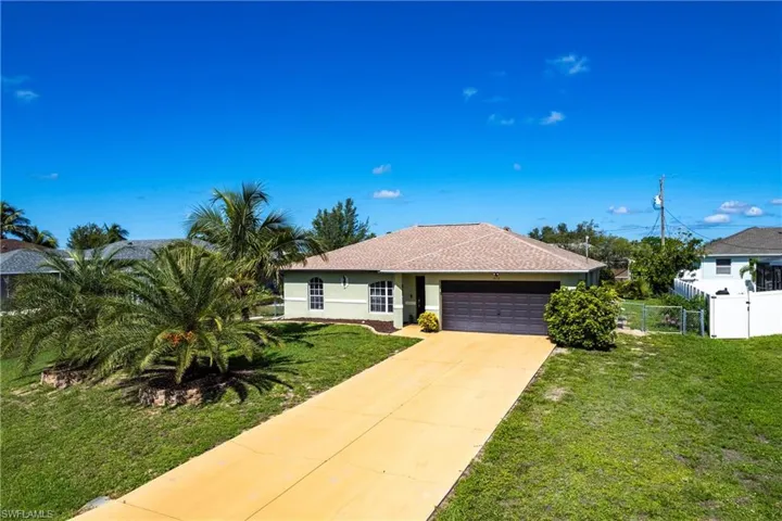 Ranch-style home with an attached garage, driveway, stucco siding, and a shingled roof