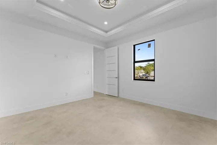 Unfurnished room with crown molding, a tray ceiling, baseboards, and recessed lighting