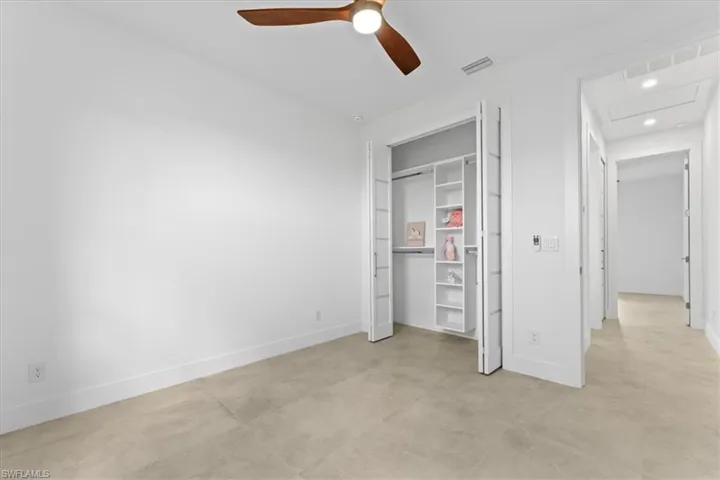 Guest bedroom with baseboards, recessed lighting, matte tile flooring, and a built out closet