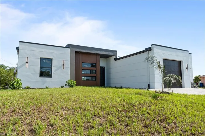 Modern home featuring an attached garage and a front lawn