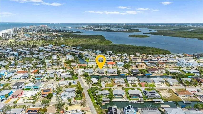 Aerial view of property and surrounding area featuring a large body of water and nearby suburban area -Virtually enhanced