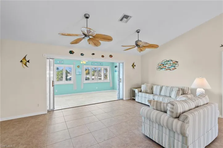 Living area with Florida sunroom in the background -Virtually enhanced