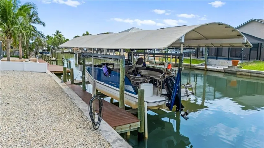 Dock area featuring boat lift and a Gulf access canal -Virtually enhanced