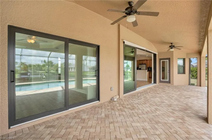 View of patio with glass enclosure and ceiling fan