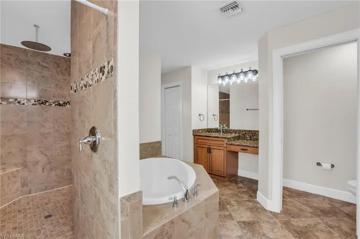 Full bathroom with plus walk in shower, tile flooring, toilet, and vanity