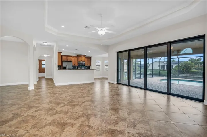 Unfurnished living room with a tray ceiling and a healthy amount of sunlight