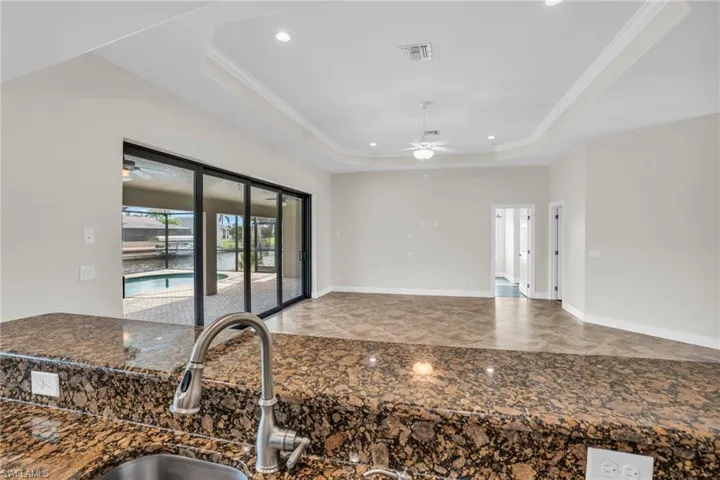 Kitchen featuring tile floors, ceiling fan, and a raised ceiling