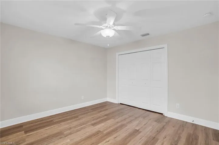 Unfurnished bedroom with ceiling fan, a closet, and wood-type flooring