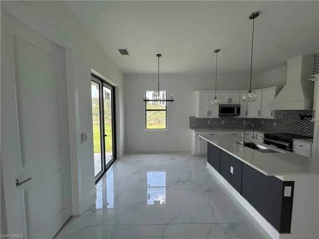 Dining area with light marble flooring and a chandelier