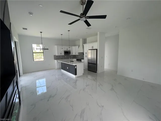 Kitchen featuring appliances with stainless steel finishes, hood range, and a backsplash