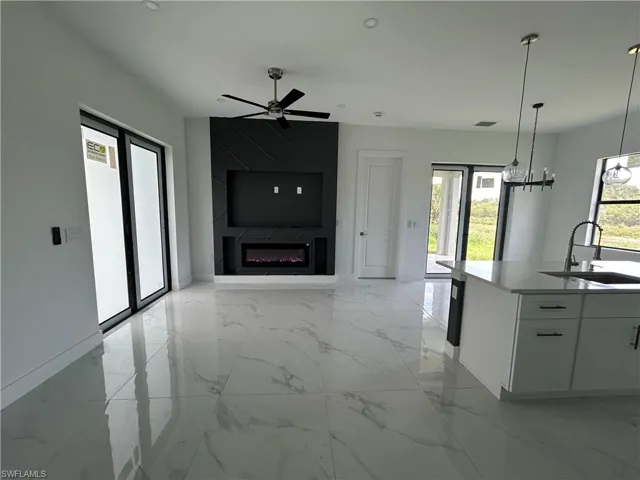 Living room featuring a large fireplace, decorative display, and ceiling fan