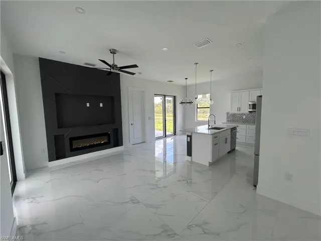 Open floor plan with light marble flooring, stainless steel appliances, and recessed lighting