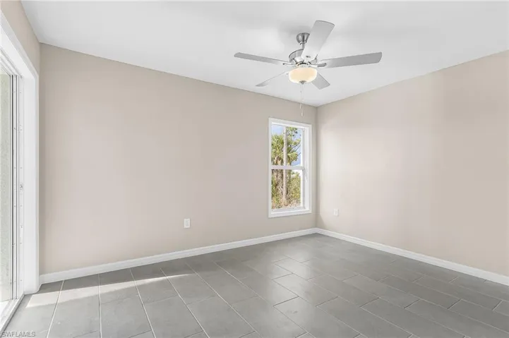 Unfurnished room featuring a ceiling fan and baseboards