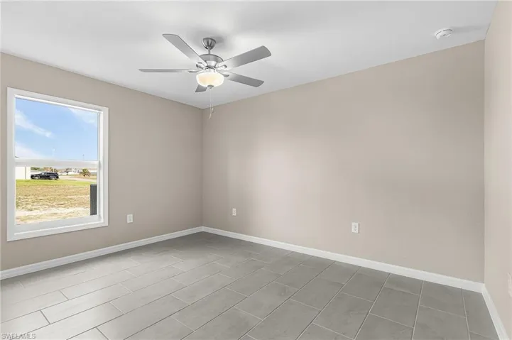 Spare room with a ceiling fan and baseboards