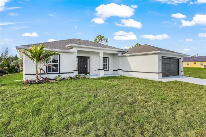 View of front of home featuring a front lawn, stucco siding, driveway, a garage, and roof with shingles