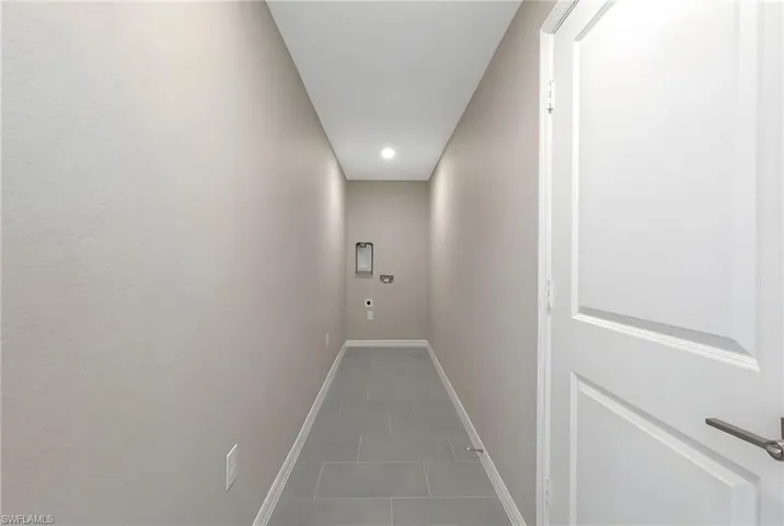 Corridor with dark tile patterned flooring and recessed lighting