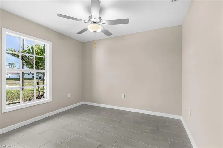 Spare room featuring ceiling fan and baseboards