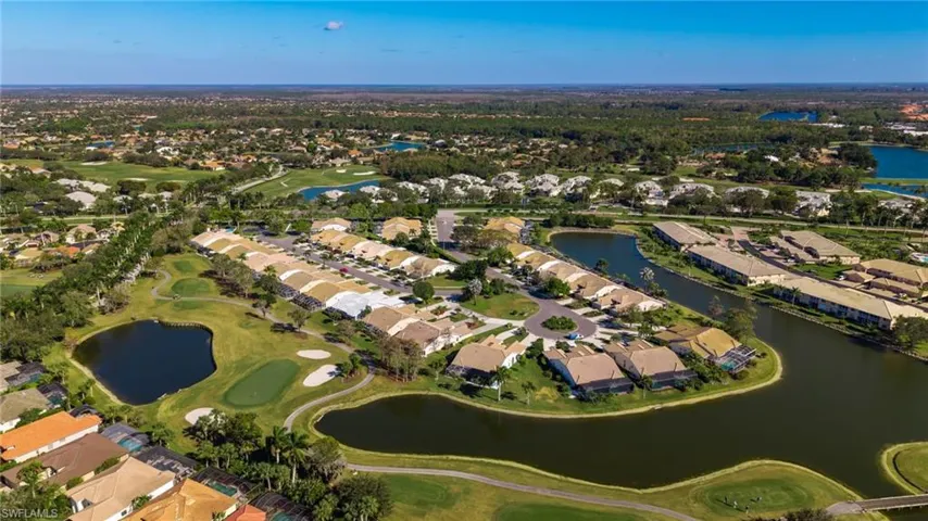 Aerial perspective of suburban area featuring a golf club and a large body of water