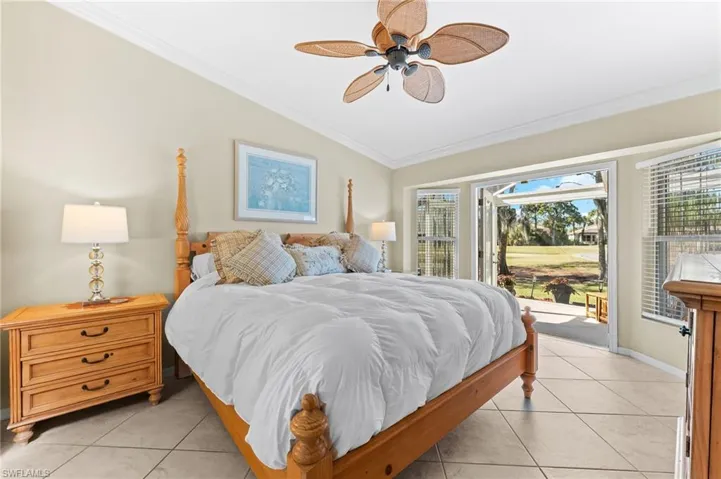 Bedroom with vaulted ceiling, crown molding, access to outside, a ceiling fan, and light tile patterned floors