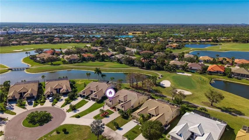 Aerial view of residential area featuring a golf club and a nearby body of water