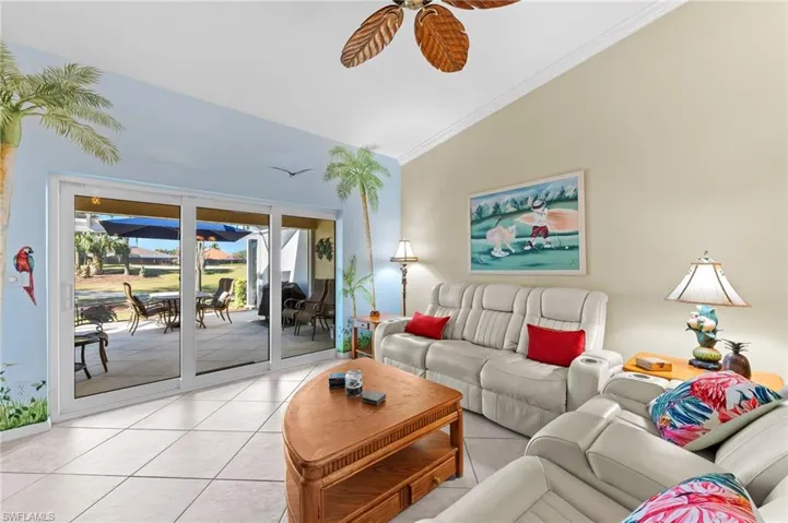 Living room featuring ornamental molding, a ceiling fan, and light tile patterned floors