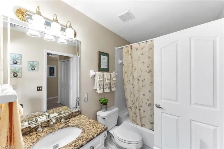 Full bath featuring vanity and shower / bath combo with shower curtain