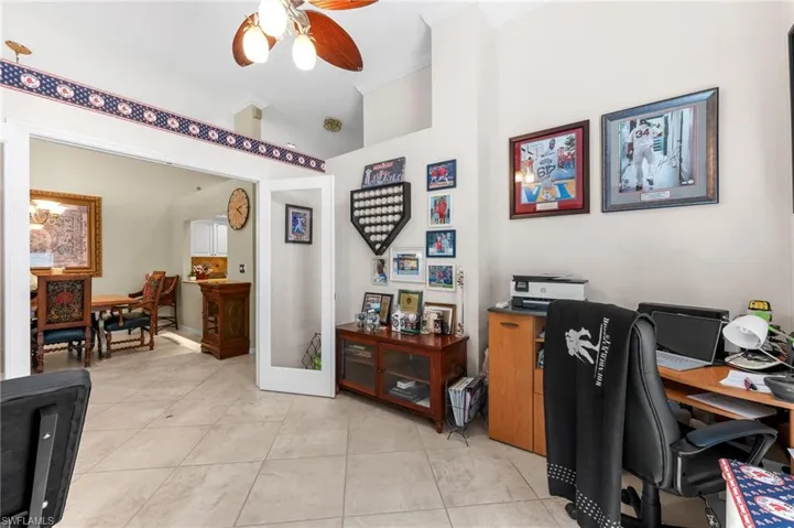 Office area with crown molding, ceiling fan, and light tile patterned flooring