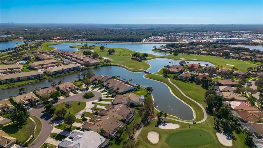 Aerial view of property and surrounding area with a golf club and nearby suburban area