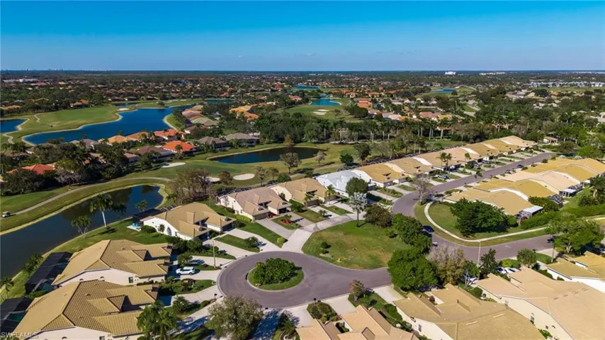 View of property location featuring nearby suburban area, a golf course, and a nearby body of water