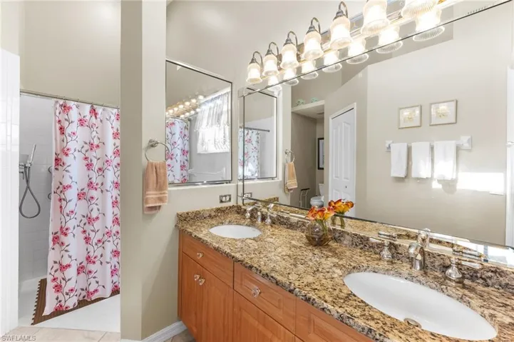 Full bathroom with double vanity and shower / bath combination with curtain