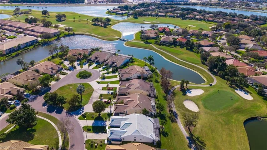 View of property location with a golf course, a large body of water, and nearby suburban area