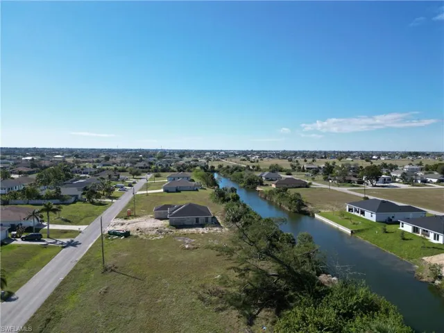 Birds eye view of property with a water view and a residential view