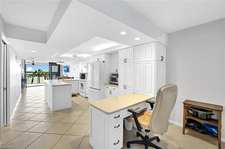 Office space featuring light tile patterned floors, recessed lighting, a raised ceiling, and ceiling fan