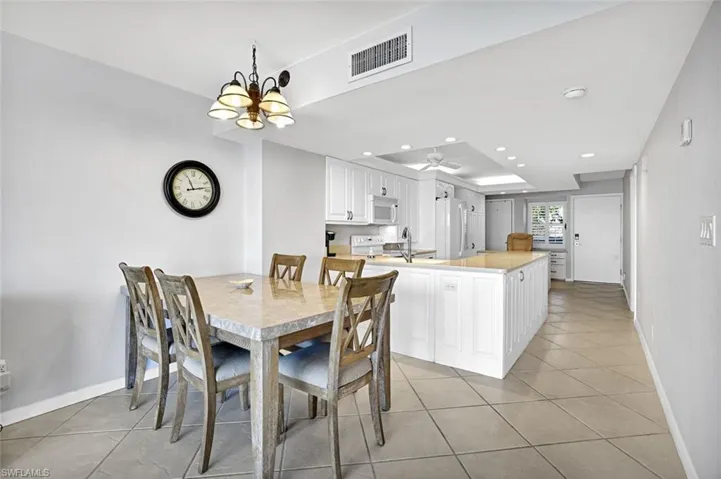 Dining space featuring visible vents, recessed lighting, light tile patterned floors, and a raised ceiling