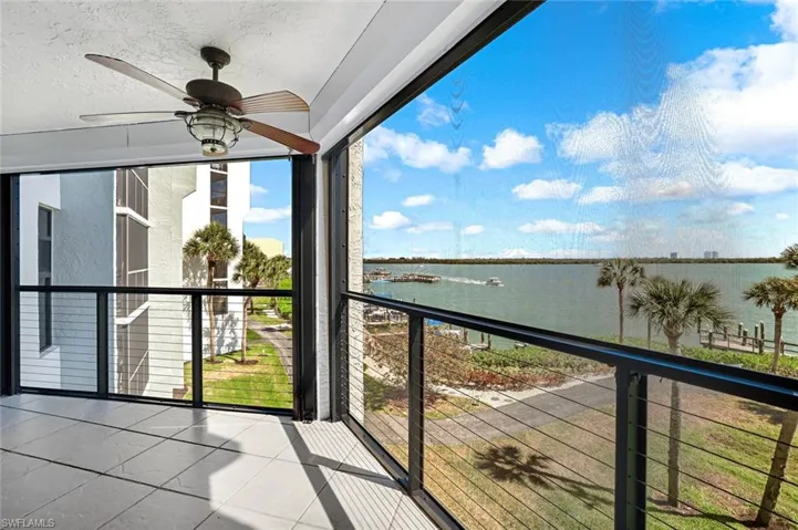 Balcony featuring a water view and ceiling fan