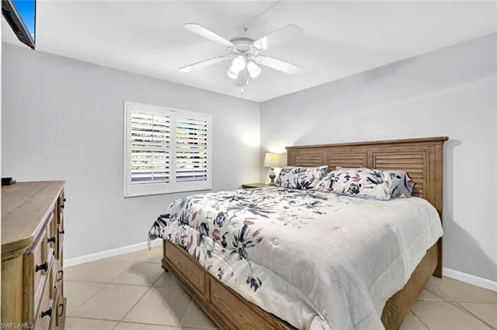 Bedroom featuring baseboards, ceiling fan, and light tile patterned flooring