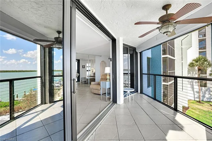 Unfurnished sunroom with a water view and ceiling fan