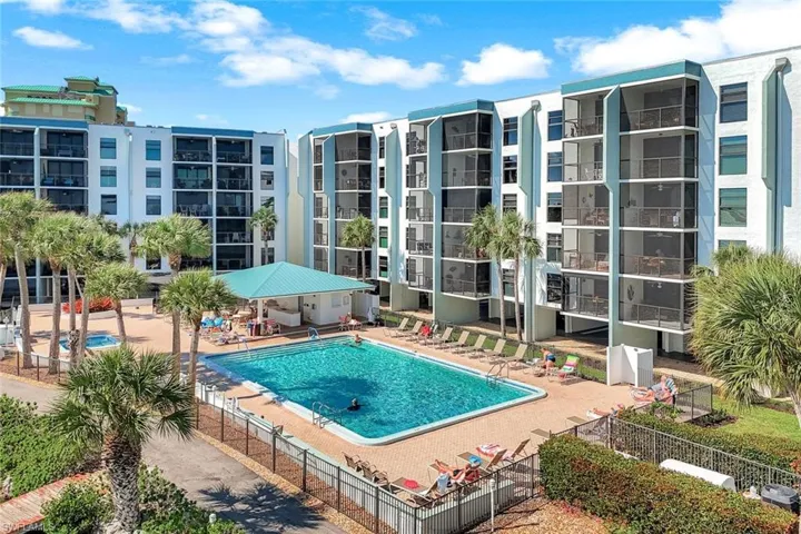 Community pool with a patio area and fence